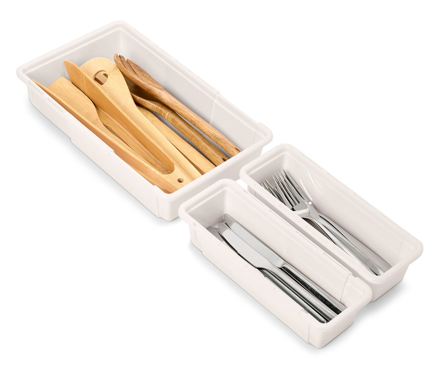 Sets von weißen Schubladen-Organisatoren mit Küchenutensilien aus Holz und Silber.