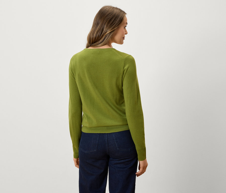 Rückansicht einer Frau mit grünem Pullover und dunkelblauen Jeans.