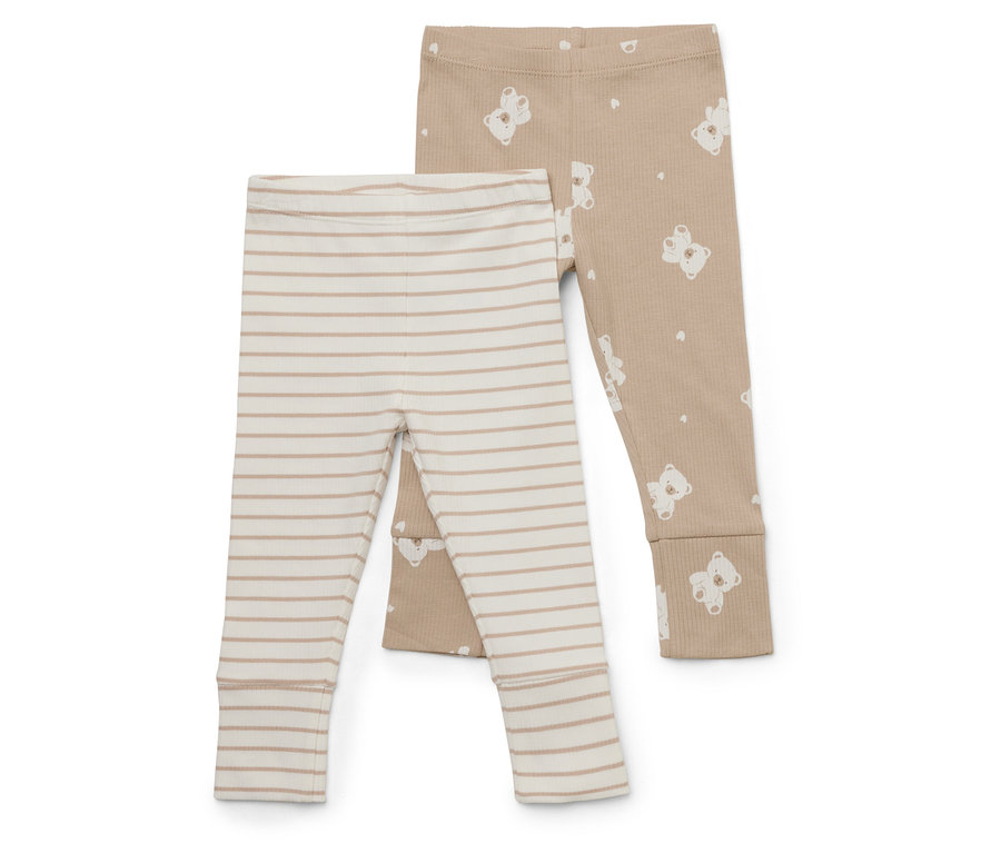 Zwei Babyhosen liegen übereinander. Eine ist beige mit weißen Streifen, die andere ist hellbraun mit weißen Bären.