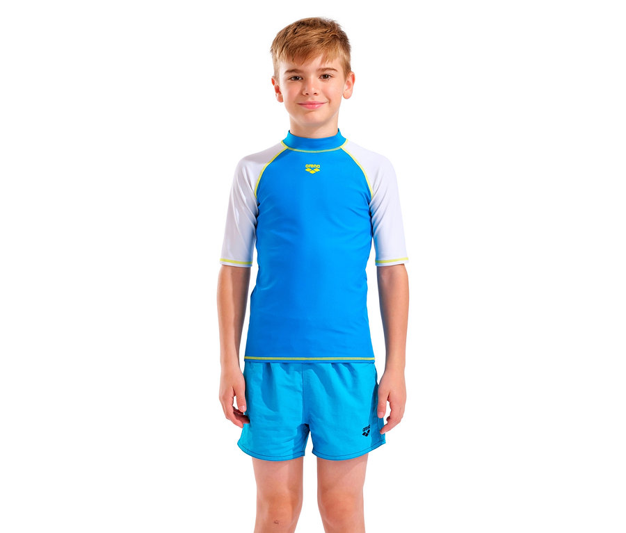 Junge trägt blaues Arena-Schwimmshirt mit weißen Ärmeln und blaue Shorts.