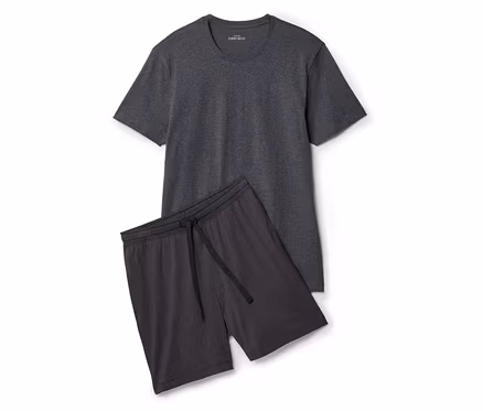Graues T-Shirt liegt neben Shorts mit Kordelzug auf weißem Grund.