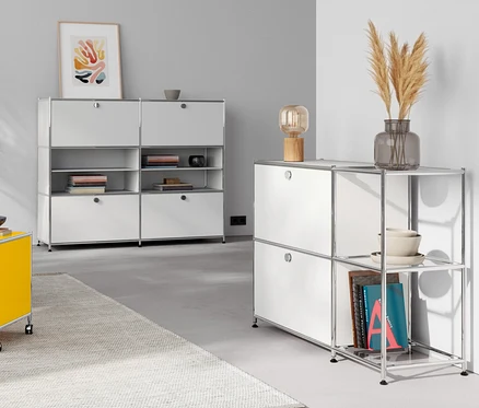 Wohnzimmer mit Tischleuchte aus Holz auf einer Kommode Metall »CN3« mit 4 Klappenfächern, weiß. Gelber Beistelltisch Metall »CN3« mit Klappfach.