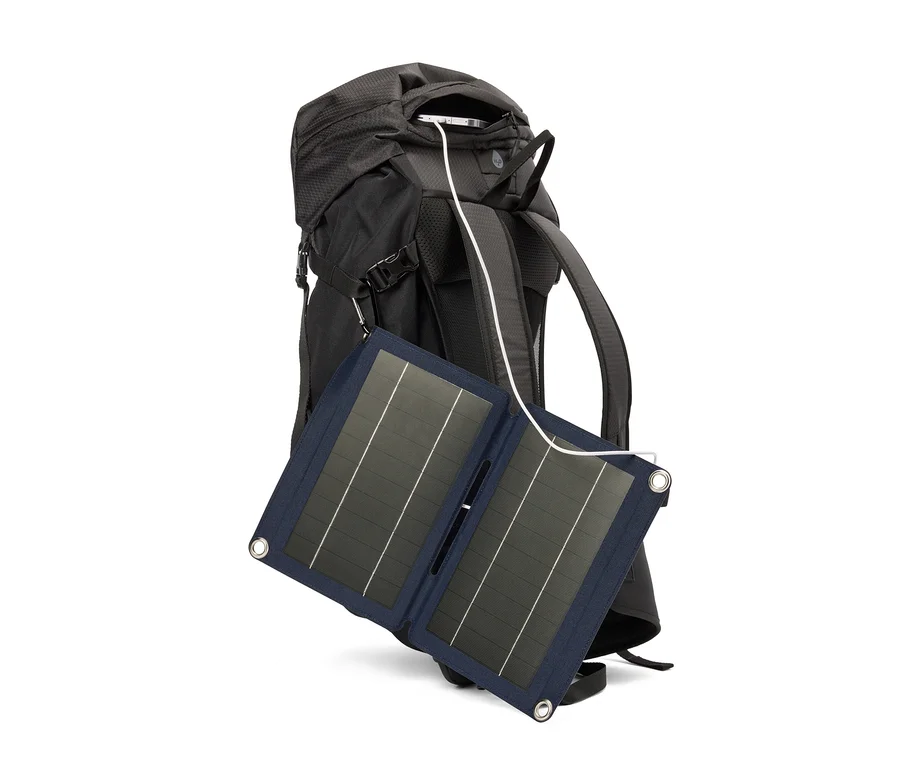 Ein schwarzer Rucksack mit einem Solarpanel, das mit einem Kabel verbunden ist.