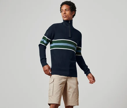 Mann trägt einen dunkelblauen Troyer-Pullover mit Streifen und Khaki-Shorts.