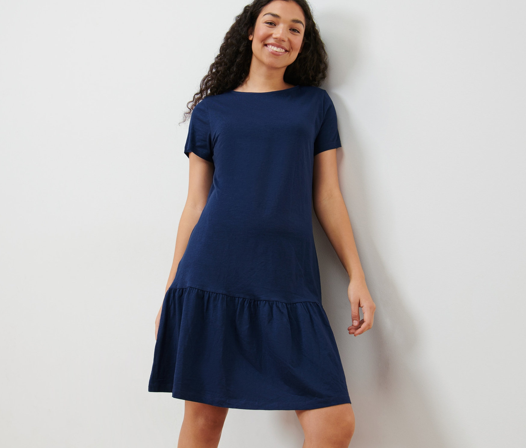 Frau posiert in einem Jerseykleid mit Volant.