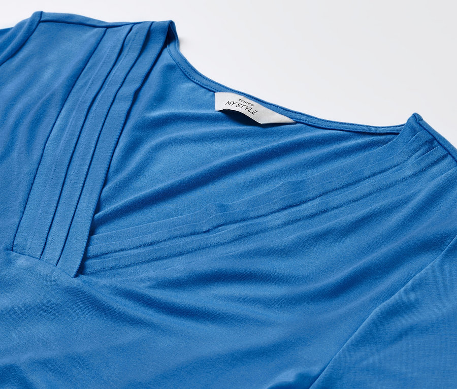 Nahaufnahme eines kobaltblauen Shirts mit Faltendetail.