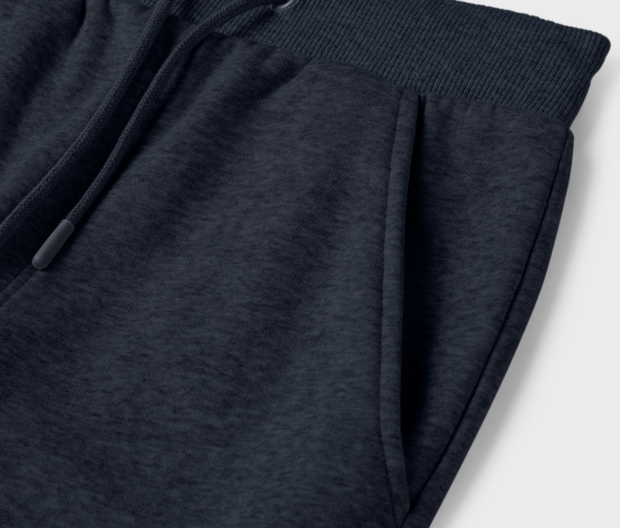 Detailaufnahme einer dunkelblauen Jogginghose mit Tasche und Kordelzug in der Taille.