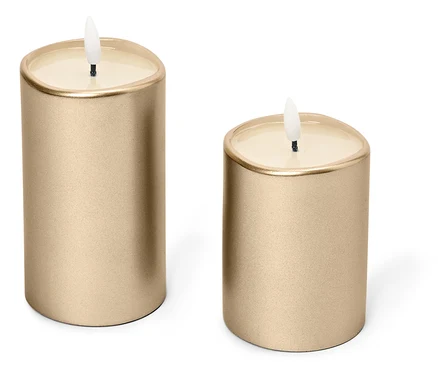 Zwei goldene Kerzen stehen auf einem weißen Hintergrund.