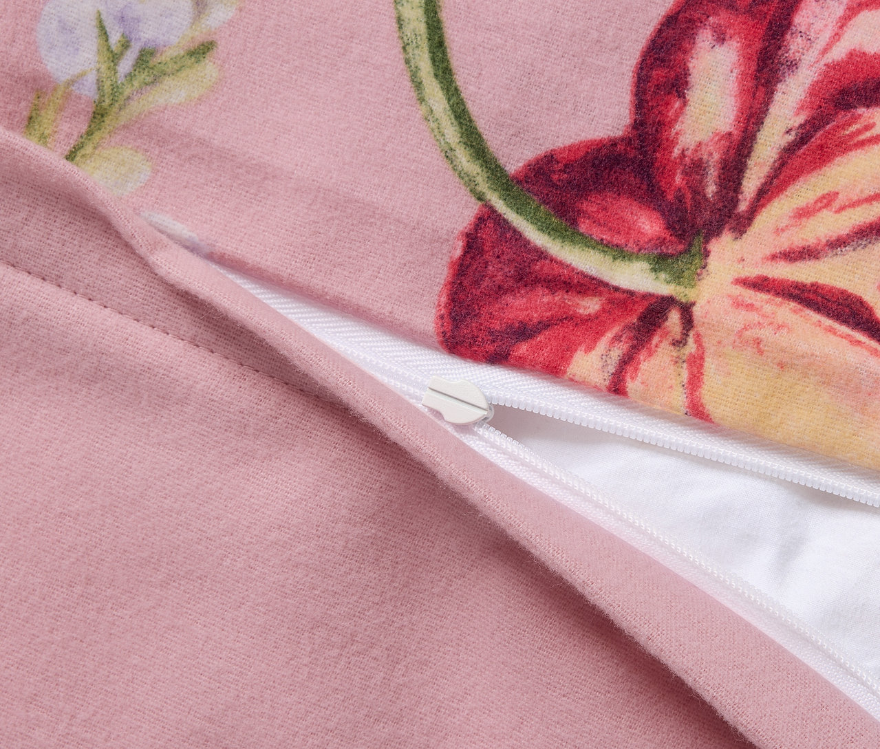 Detailansicht von rosa Biber-Bettwäsche in Übergröße mit Blumenmuster und Reißverschluss.