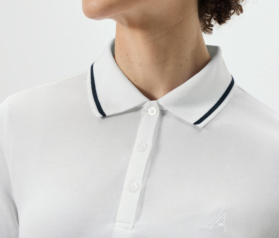 Oberkörper einer Person, die ein weißes Funktionspoloshirt trägt.