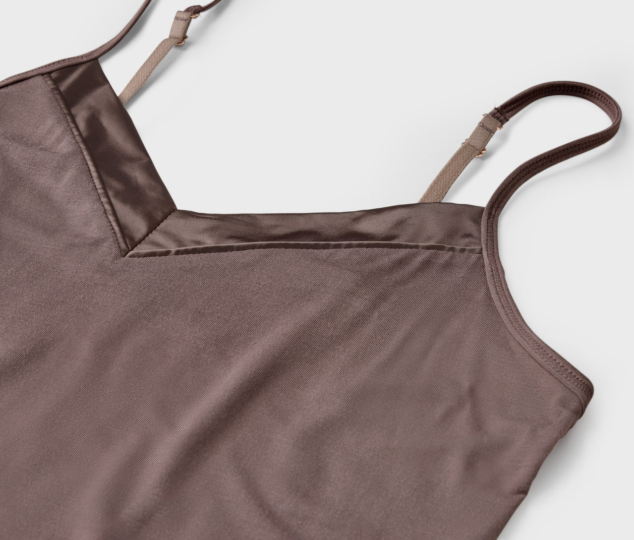 Detailaufnahme eines braunen Satintops mit verstellbaren Trägern.