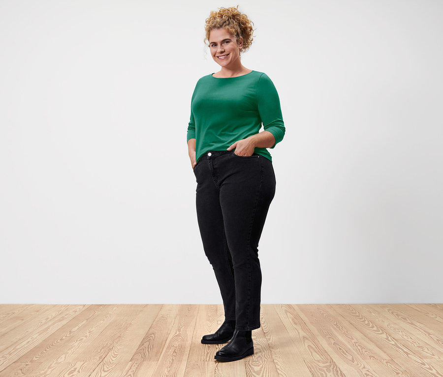 Frau posiert in grünem Shirt mit 3/4-Arm.