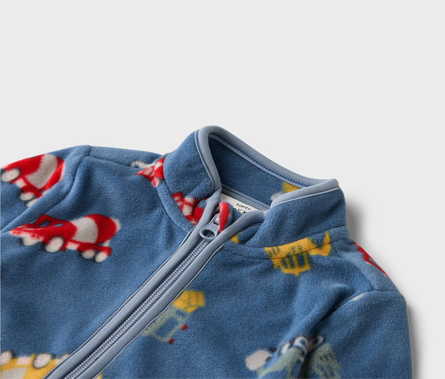 Nahaufnahme einer blauen Fleecejacke mit Reißverschluss und bunten Fahrzeugmotiven.