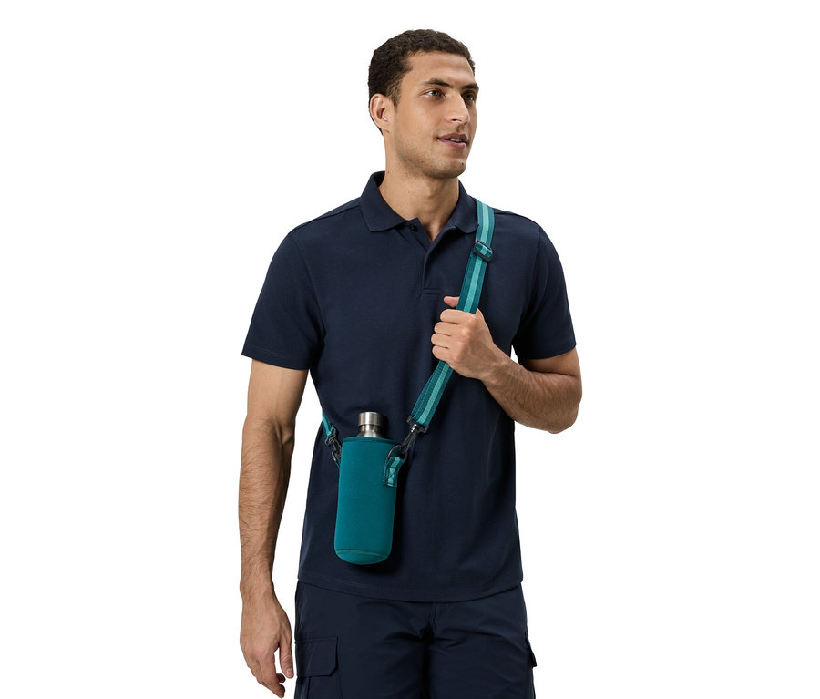 Mann trägt ein blaues Poloshirt und eine blaue Hose. Er hat eine grüne Flasche mit einem Tragegurt um die Schulter.