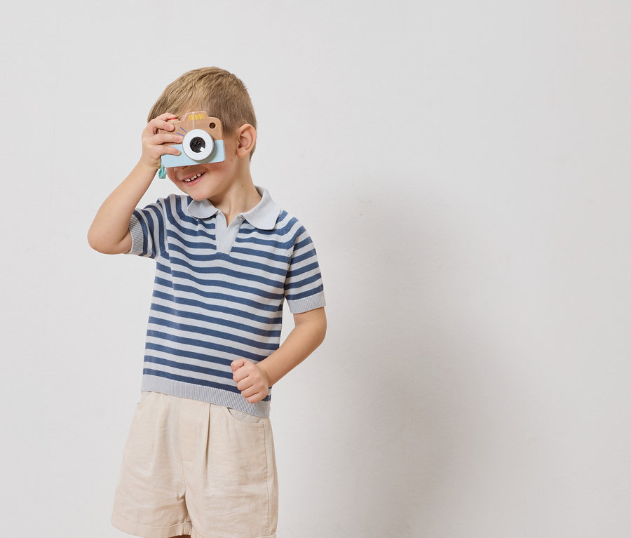 Ein Junge hält eine Spielzeugkamera vor sein Auge.
