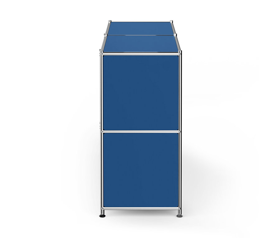 Ein schmales, hohes, modulares Regal mit zwei übereinander gestapelten blauen Fächern und einem Chromrahmen.