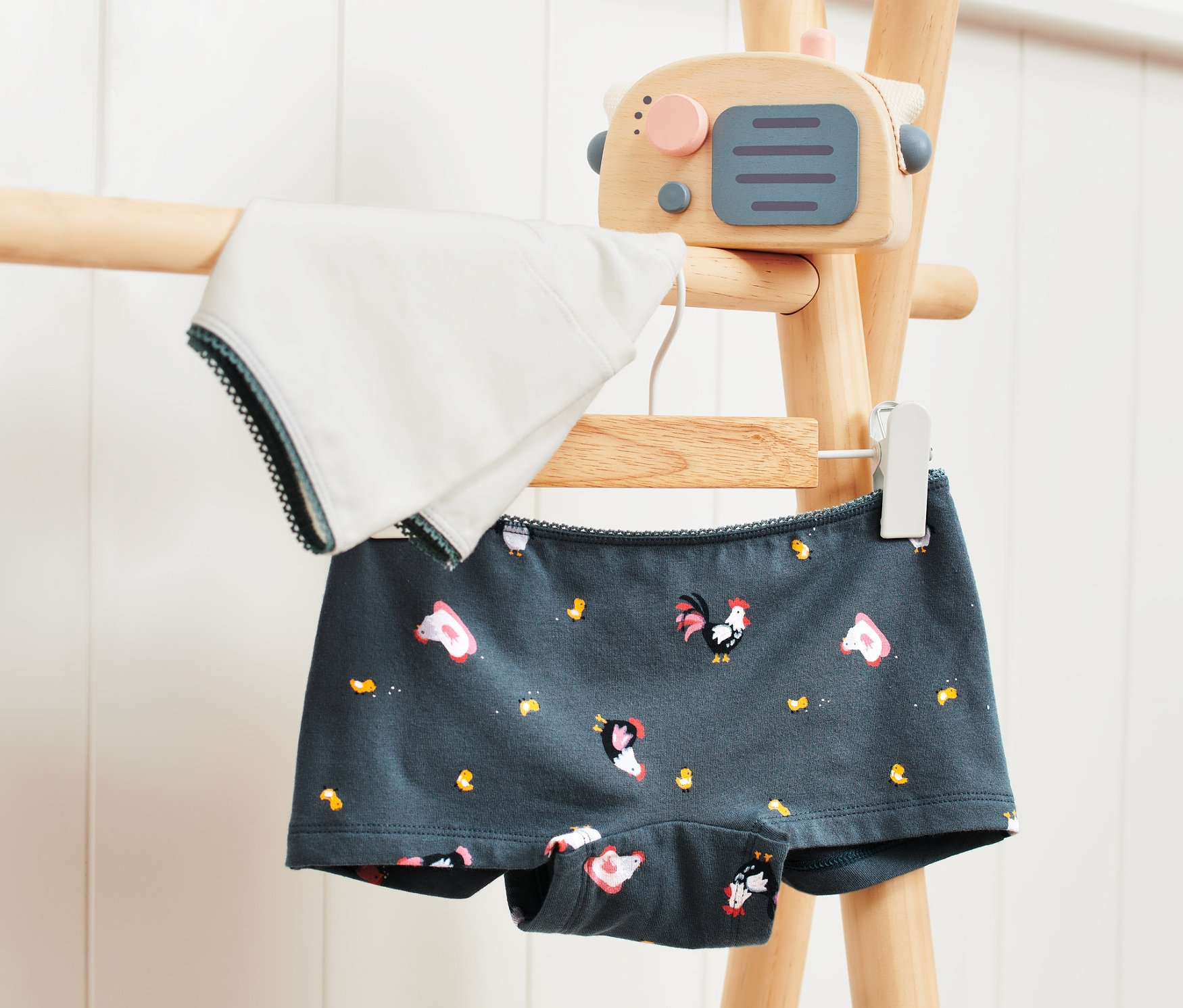 Zwei Mädchen-Pantys hängen auf einem Holzständer.