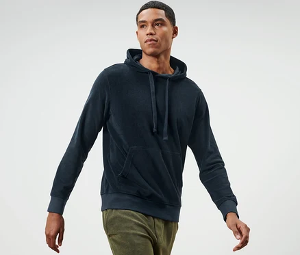 Mann geht und trägt einen Frottee-Hoodie.