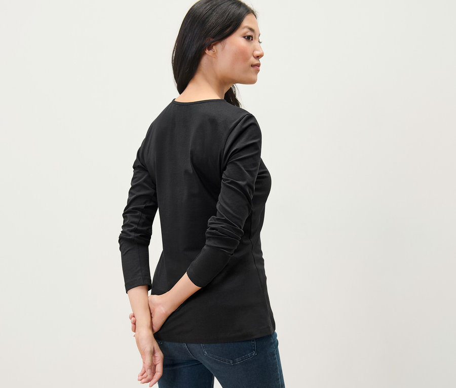 Frau trägt ein schwarzes Langarmshirt.