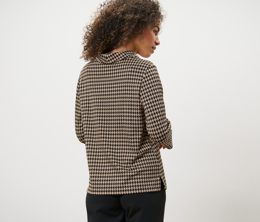 Rückansicht einer Frau mit lockigem Haar, die ein Sweatshirt mit 3/4-Arm und Hahnentrittmuster trägt.