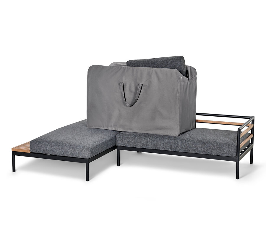 Eine graue Premium-XXL-Aufbewahrungstasche für Outdoor-Kissen liegt auf einem grauen Sofa.
