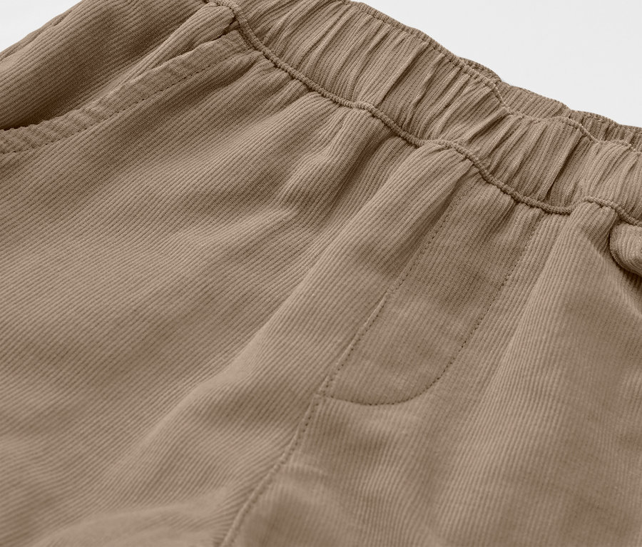 Detailaufnahme einer braunen Kinder-Cord-Outdoorhose mit elastischem Bund und Tasche.