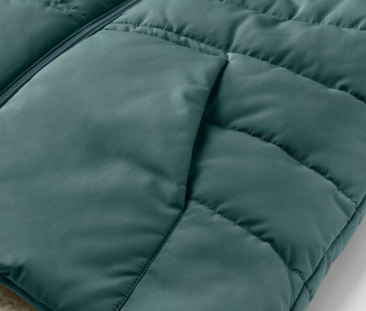 Detail einer Kinder-Teddyplüsch-Steppweste mit Tasche.