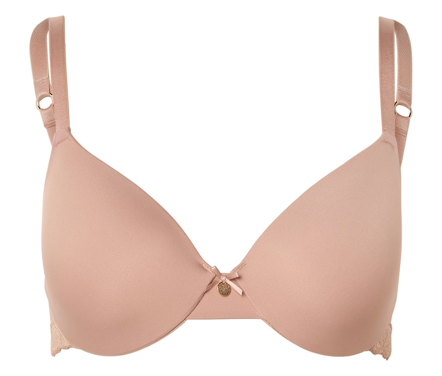 Ein hautfarbener BH mit verstellbaren Trägern, Schleife und kleinem goldenen Anhänger in der Mitte.