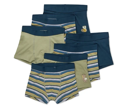 Sieben Kinderboxershorts in verschiedenen Farben und Mustern liegen übereinander.