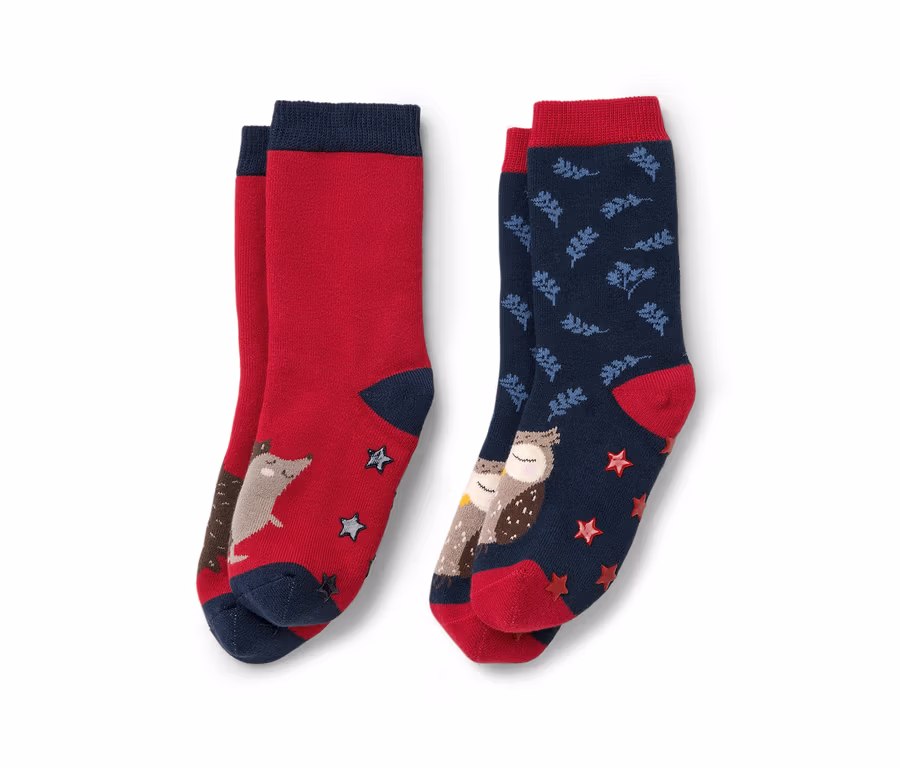 Zwei Paar Kinder-Antirutsch-Socken: ein rotes Paar mit Fuchs und Sternen, ein blaues Paar mit Eulen und Blättern.