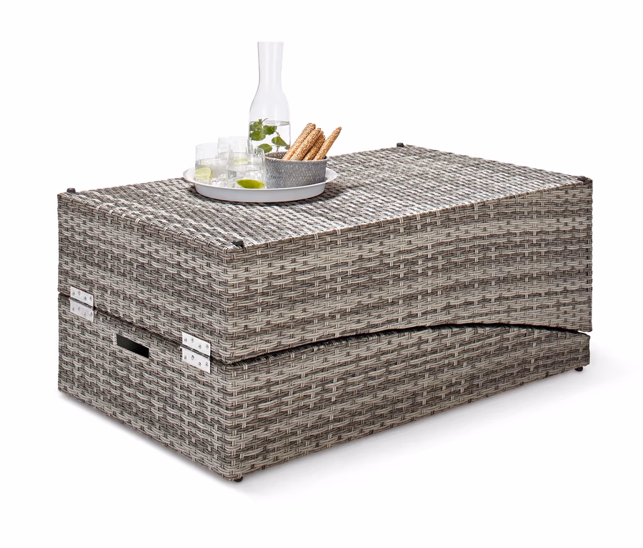 Klappbare Gartenliege aus Polyrattan mit Glaskaraffe und Gläsern auf dem Tisch.