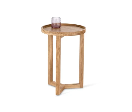 Ein runder Beistelltisch mit einem Glas darauf.