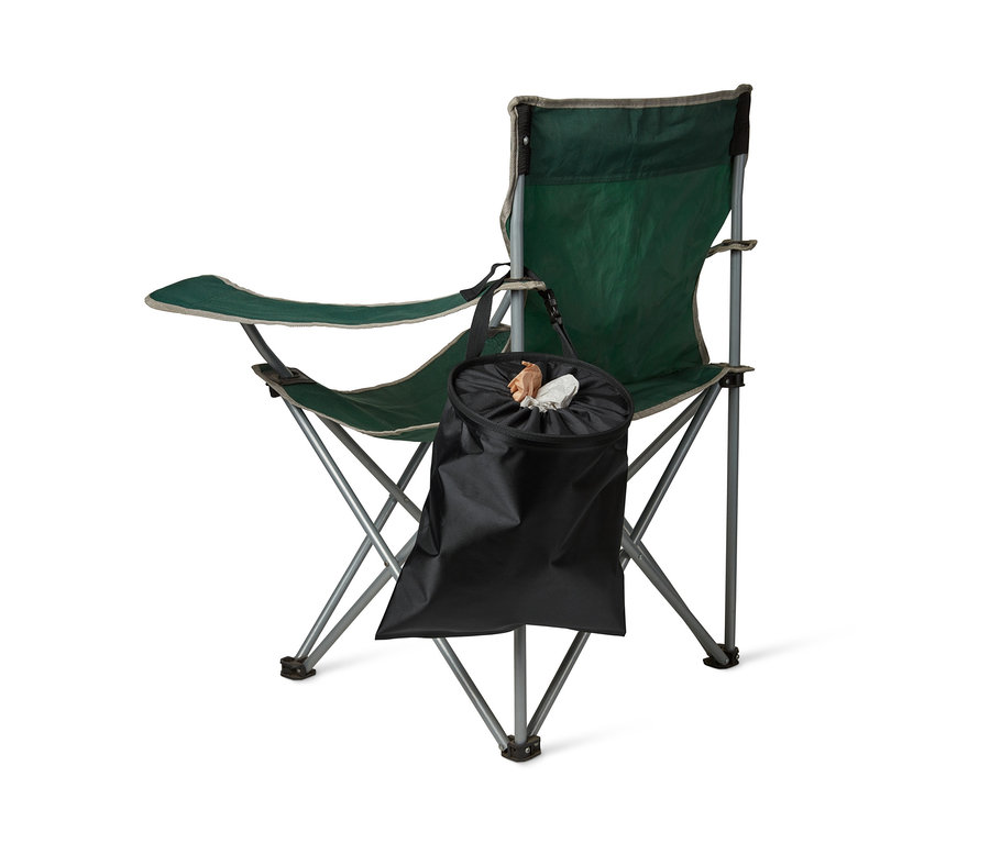 Grüner Campingstuhl mit Universal-Mülleimer in Schwarz, der an der Seite des Stuhls hängt.