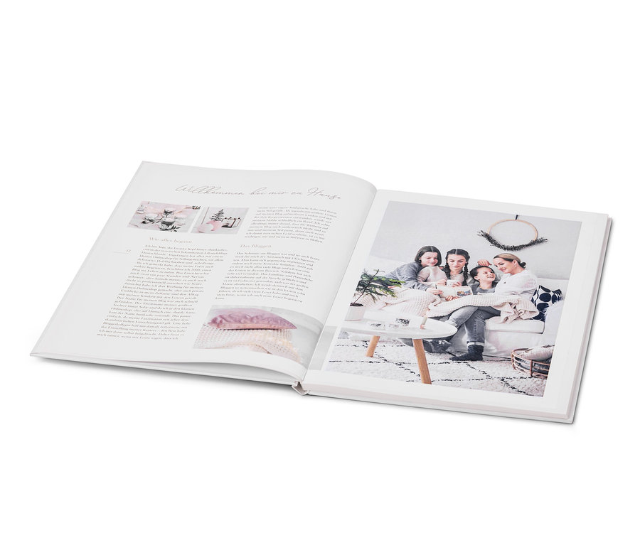 Geöffnetes Buch mit Foto von vier Personen, die auf einem Sofa sitzen, mit dem Buch »Weihnachtszauber«