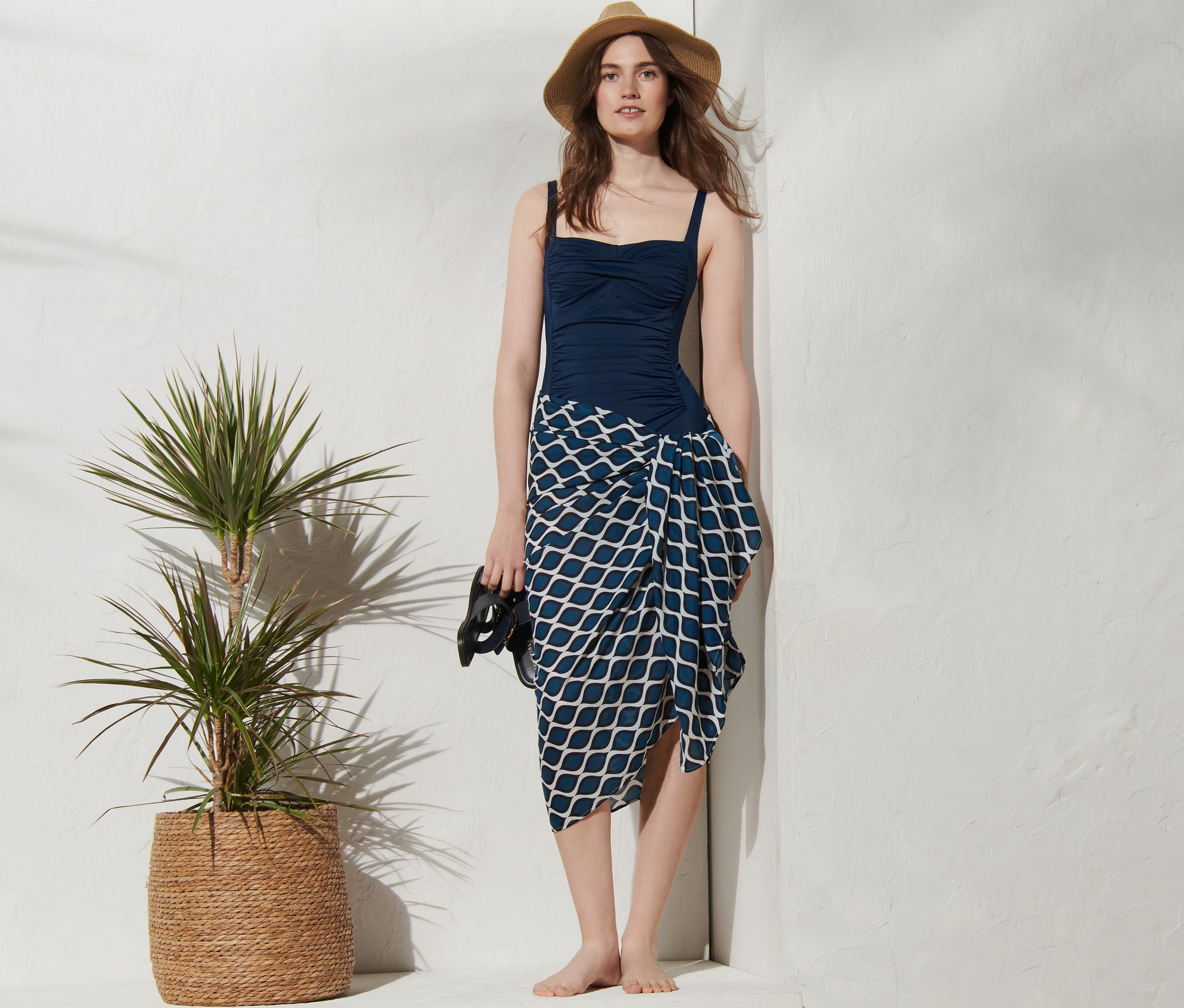 Frau im blauen Badeanzug und gemustertem Multifunktionstuch.