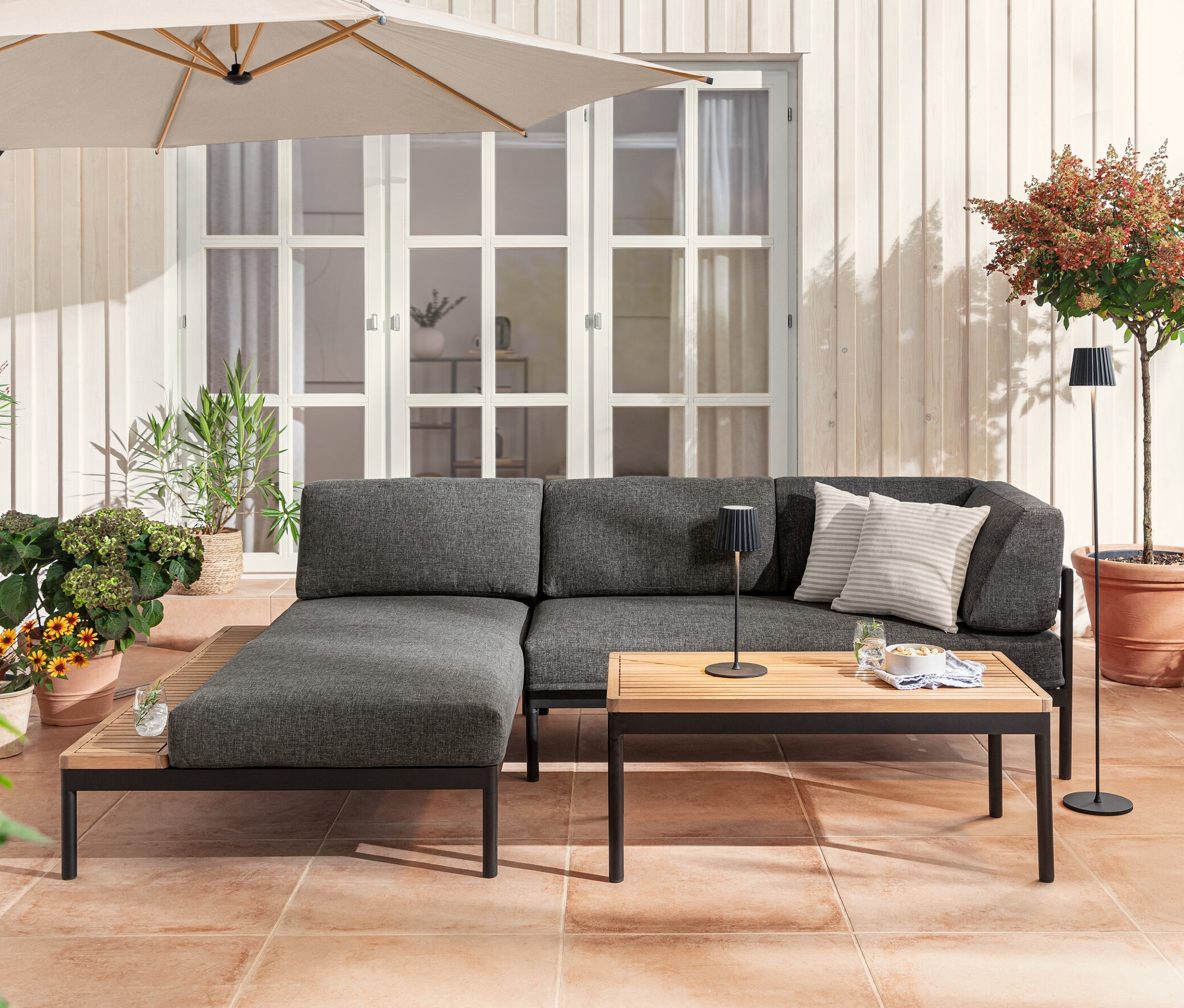 Eine Lounge-Ecke »Elin« mit LED-Akku-Outdoor-Tischleuchte und Stehleuchte in Schwarz und 2 Outdoor-Kissen in Leinen-Haptik.