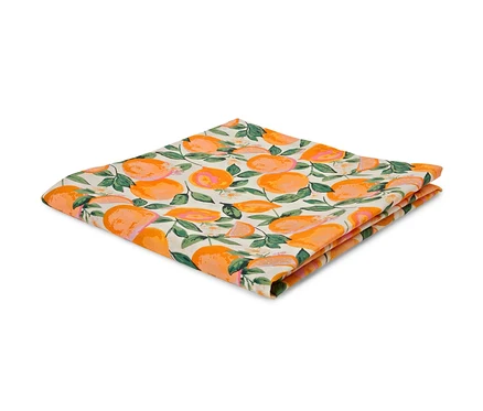 Eine gefaltete, abwischbare Tischdecke mit Orangen- und Blättermuster.