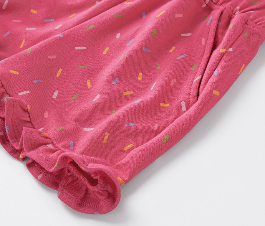 Detailaufnahme von Kinder-Sweat-Shorts mit bunten Streuseln und Rüschen.