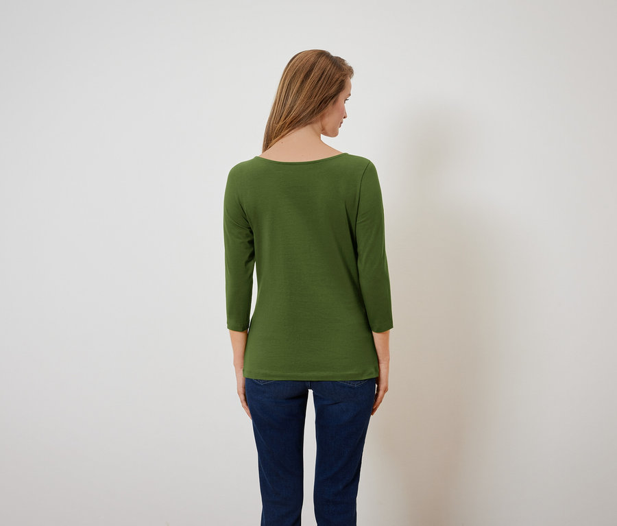 Frau von hinten trägt ein grünes Dreiviertelarmshirt und blaue Jeans.