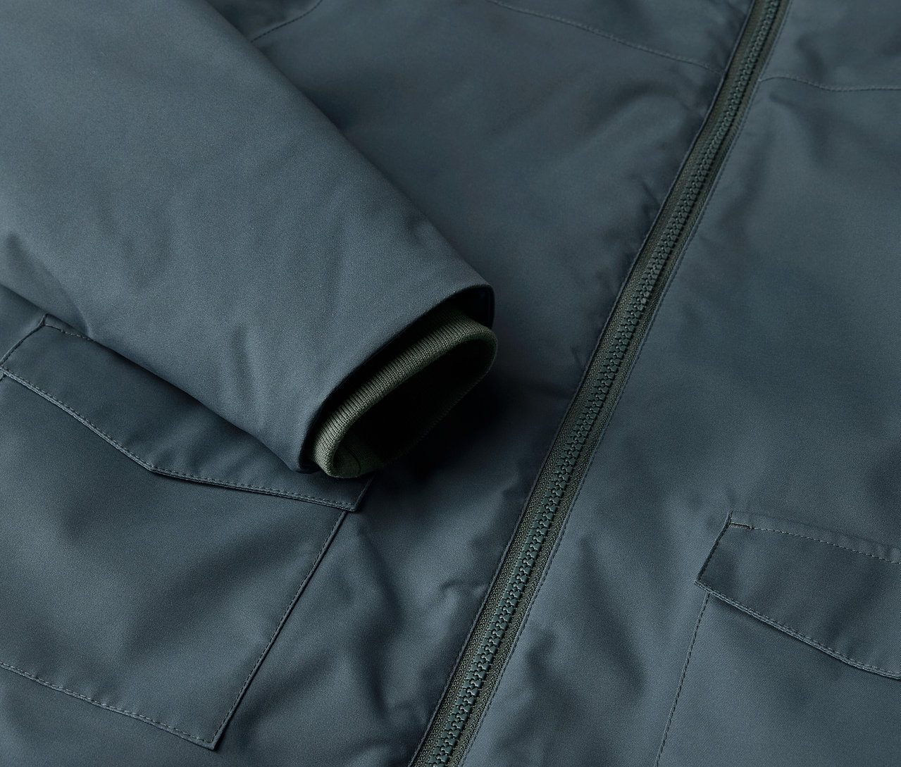 Detailaufnahme eines Kinder-Winterparkas mit Tasche und Reißverschluss.