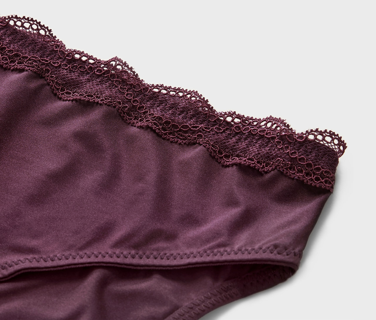 Detailaufnahme von 5 Slips in Lila mit Spitze.