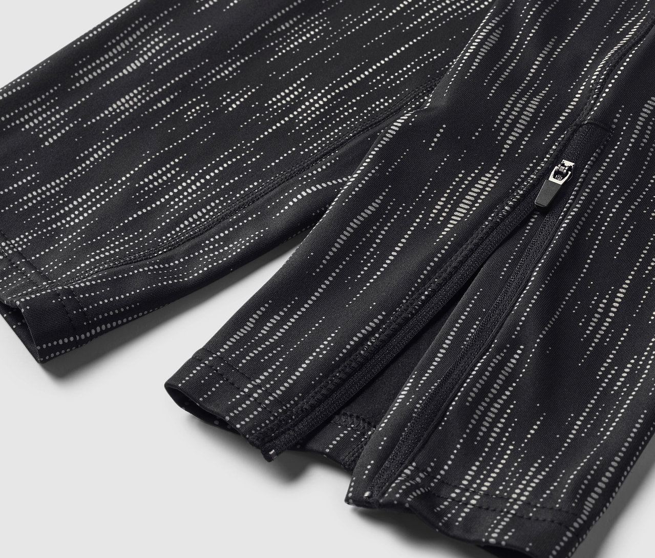 Detailaufnahme einer schwarz-weiß gemusterten Hose mit Knöchelreißverschluss.