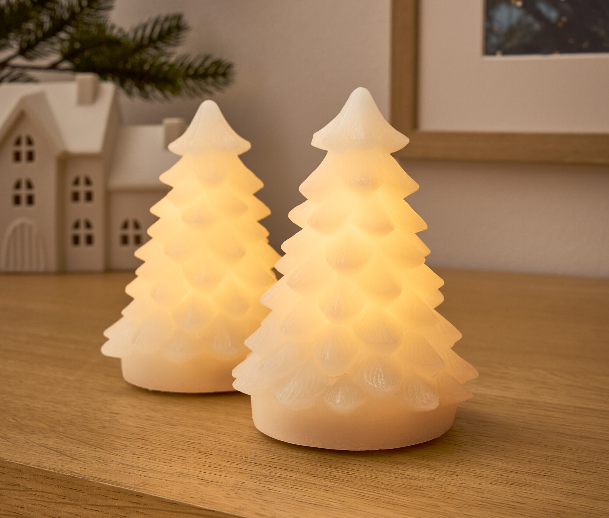 Zwei leuchtende Bäume auf einer Holzoberfläche.