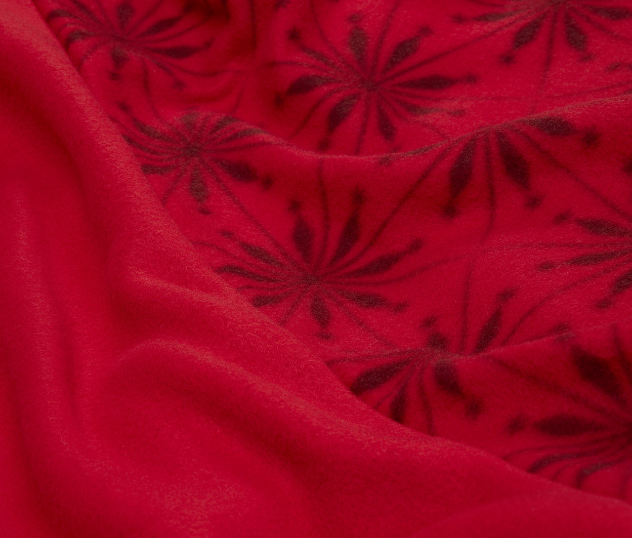 Detailaufnahme eines roten Stoffes mit dunklem Blumenmuster.