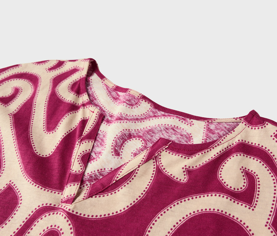 Nahaufnahme eines Oberteils mit V-Ausschnitt und abstraktem Muster in Magenta und Beige.