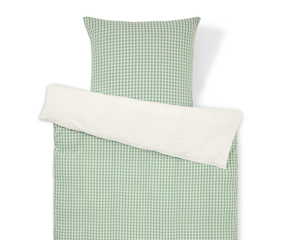 Draufsicht auf ein Bettset mit grün-weiß kariertem Muster und einem weißen Kissenbezug.