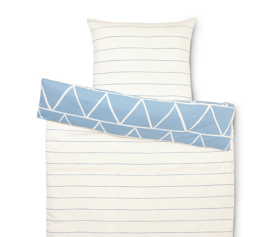Bettwäscheset mit weißen und blauen Streifen, Kissenbezug und einer blauen Rolle mit weißen Dreiecken.