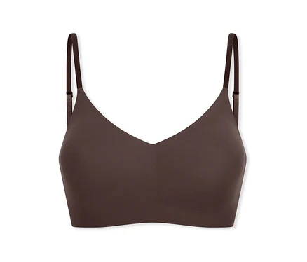 Ein dunkelbrauner, nahtloser, bügelloser Bralette mit dünnen, verstellbaren Trägern und V-Ausschnitt.