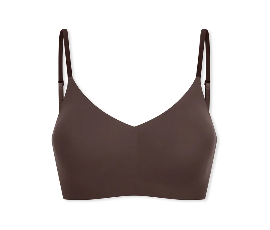 Ein dunkelbrauner, nahtloser, bügelloser Bralette mit dünnen, verstellbaren Trägern und V-Ausschnitt.