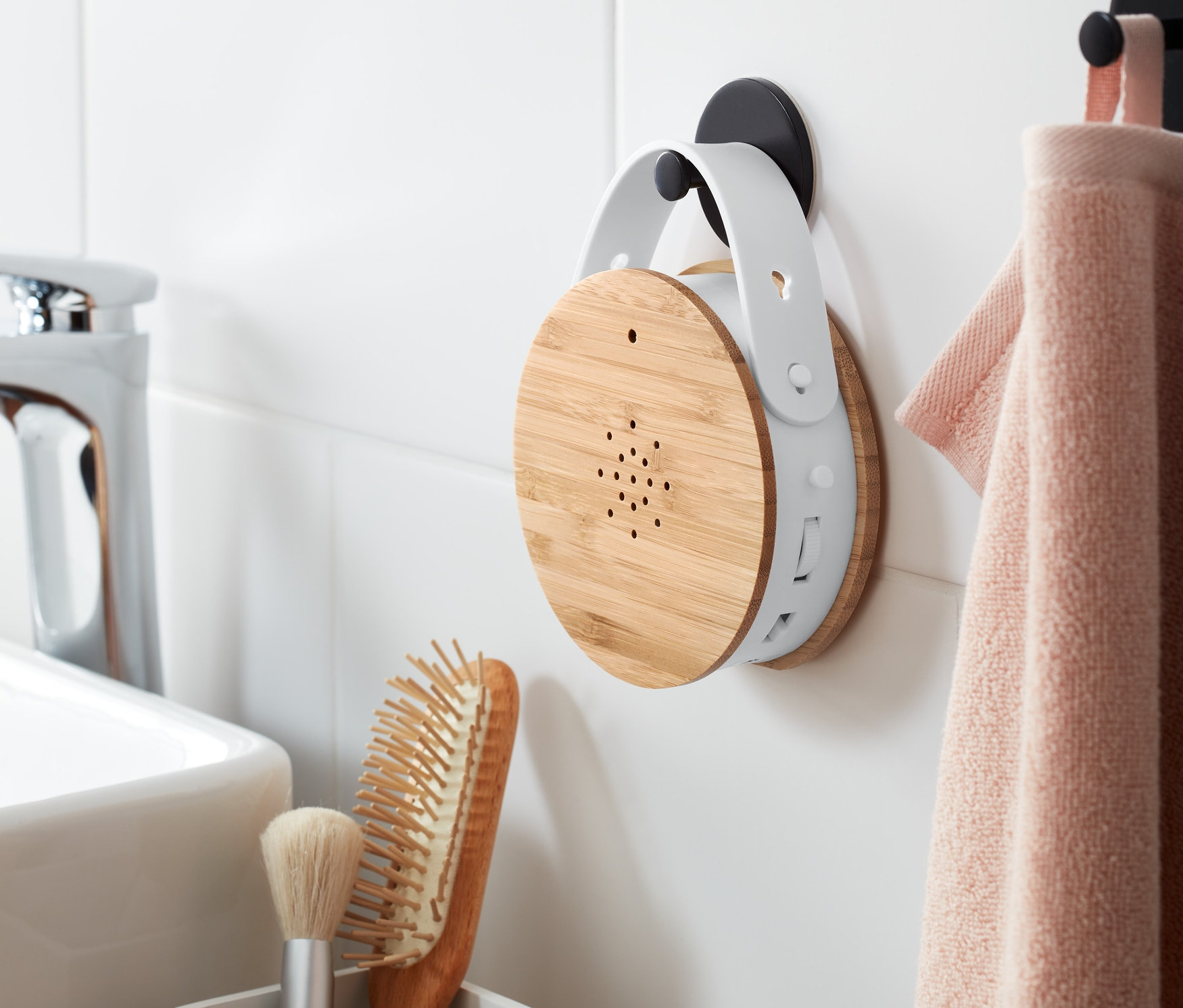 Eine Vogelgesangs-Box hängt neben einem Handtuch an der Wand.